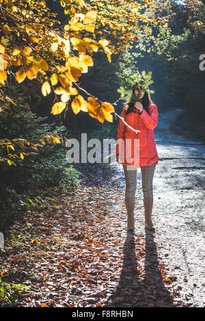 Frau versteckt sich hinter Ast Stockfoto