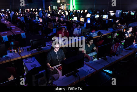 Thun, Schweiz. 10. Dezember 2015. Lange Reihen von konzentriertem Spiel Computerspieler, schwach beleuchtet, von ihren Computer-Bildschirmen am NetGame, schweizweit grösste Computer Games Convention im Thuner Expo Centre. Für 3 Tage und Nächte Turniere konkurrierende Fans und Clans in CS: Go, Age of Empires und vieles mehr. Bildnachweis: Erik Tham/Alamy Live-Nachrichten Stockfoto