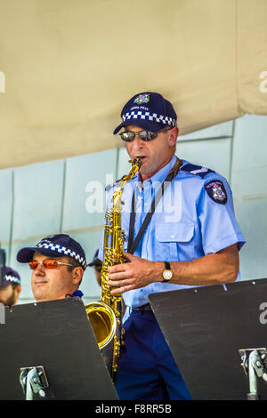 Uniformierte männlicher Polizist Saxophonisten, die live mit seinen Kollegen am Federation Square, Melbourne Australien Stockfoto