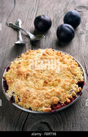 Plum Krümel Kuchen auf hölzernen Hintergrund Stockfoto