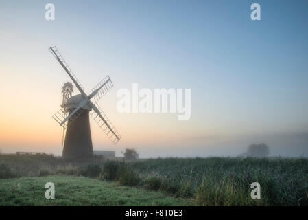 Windmühle in atemberaubender Landschaft an schönen Sommer Sonnenaufgang Stockfoto