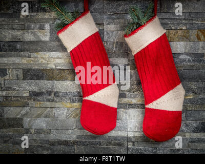 Paar rote Santa Strumpf hängen Steinmauer Stockfoto