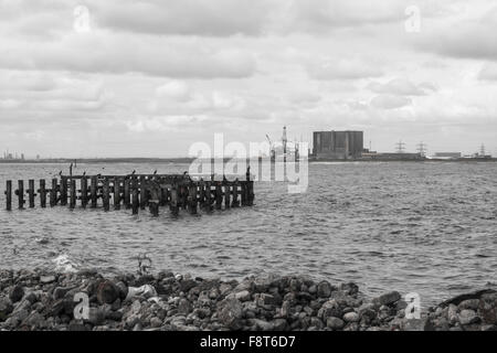 Monochrome Aussicht auf South Gare, Redcar an der Mündung des T-Stücke mit den alten Bootsanleger und industriellen Skyline einschließlich der Kernkraftwerk Stockfoto