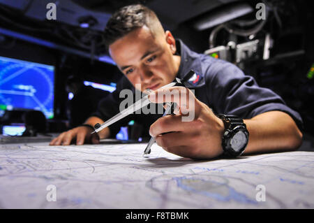 Operations Specialist verfolgt einen Kurs auf dem Chart Board auf dem amphibious Transport Dock Schiff USS New Orleans (LPD 18) während des Trainings Stockfoto