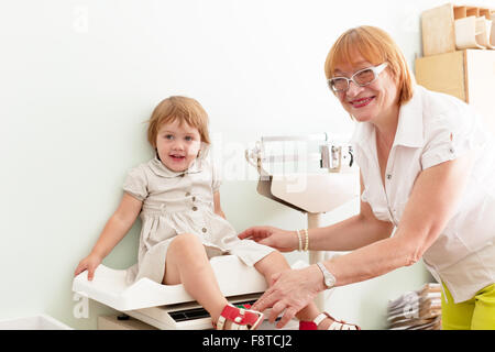 Kinderarzt wiegt das Baby mit elektronischen wiegt Stockfoto