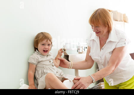 Kinderarzt wiegt das Baby mit elektronischen wiegt Stockfoto