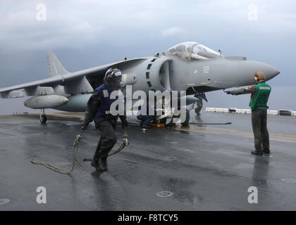 Matrosen Unterlegkeile entfernen und Ketten aus einer italienischen AV-8 b Harrier an Bord der amphibischen Angriff Schiff USS Kearsarge Stockfoto