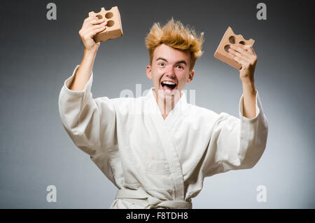 Lustige Karate-Kämpfer mit Lehmziegel Stockfoto