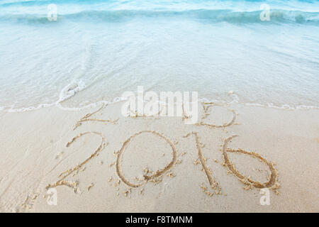 Neues Jahr 2016 ist kommenden Konzept - Inschrift 2015 und 2016 auf einen Sandstrand mit kommenden Welle Stockfoto