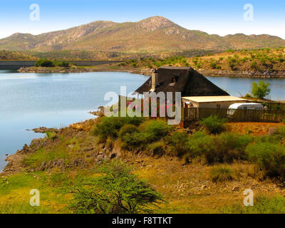 Landschaft mit einem kleinen Haus, See Oanob, Bush, Akazie Kameldornbäume (Vachellia Erioloba) und Berge in zentral-Namibia, Stockfoto