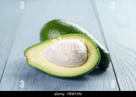 Reife grüne Avocado auf blauen Holztisch Stockfoto