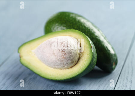 Reife grüne Avocado auf blauen Holztisch Stockfoto