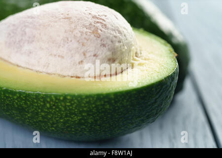 Reife grüne Avocado auf blauen Holztisch Stockfoto