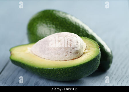 Reife grüne Avocado auf blauen Holztisch Stockfoto