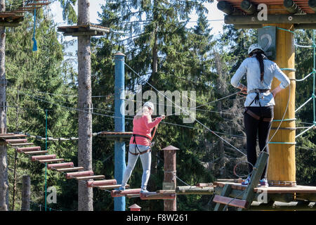 Zwei junge Frauen auf Trollandia Highwire Park Seilbahn und Hindernis-Parcours. Gubalowka Hill Zakopane Tatra County Polen Stockfoto