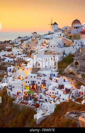 Santorini - weiße Häuser und Windmühlen bei Sonnenuntergang, Oia, Griechenland Stockfoto