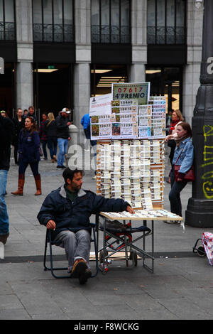 Madrid, Spanien 11. Dezember 2015: Ein Mann sitzt neben seinem Verkaufsstand und verkauft Tickets für die Weihnachtslotterie auf der Plaza Puerta del Sol im Zentrum von Madrid. Die spanische Weihnachtslotterie ist eine der ältesten der Welt und die größte der Welt in Bezug auf die Gesamtauszahlung. Das Siegerticket ist bekannt als „El Gordo“ („der große“ oder „der fette“). Quelle: James Brunker / Alamy Live News Stockfoto