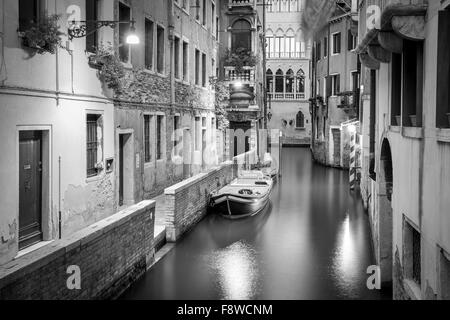 B&W Szene aus Venedig. Schmalen Kanal und Boote am Abend. Stockfoto