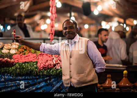 Marokkanischen Mann streckt Kebab-Spiess vor Garküche in der Jemma el Fna in Marrakesch Stockfoto