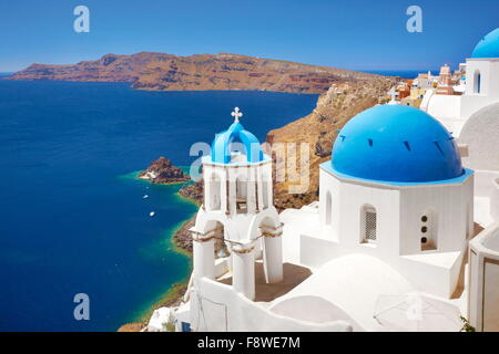 Santorini-Landschaft mit griechischen Bell Tower und weiße Kirche mit blauer Kuppel mit Blick aufs Meer, Oia, Santorin, Griechenland Stockfoto