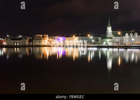 Nightime Reflexionen über Tjörnin-Sees in Reykjavik, Island. Das Konzerthaus Harpa kann am Horizont zu sehen. Stockfoto