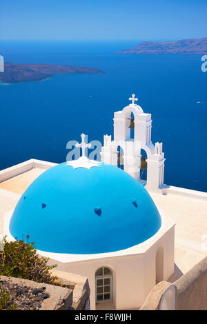 Thira Fira (Hauptstadt von Santorini) - Blick auf griechische Kirche mit blauer Kuppel, Glockenturm und blaues Meer, Insel Santorin, Griechenland Stockfoto