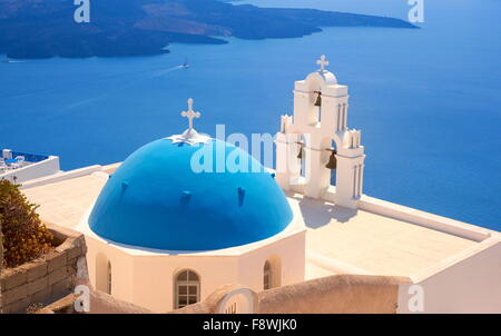 Thira (Hauptstadt von Santorini) - Blick auf griechische Kirche mit blauer Kuppel, Glockenturm und blaues Meer, Insel Santorin, Kykladen, Griechenland Stockfoto