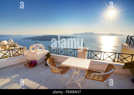 Thira (Kapital Stadt von Santorini) - Terrasse mit Blick auf das Meer und die Sonne am Himmel, Insel Santorin, Griechenland Hintergrund Stockfoto
