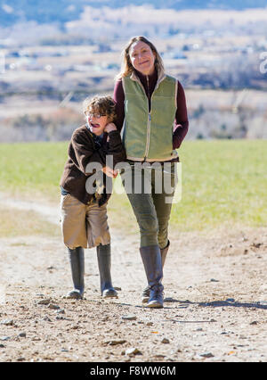 Attraktive Mutter und seinem kleinen Sohn zu Fuß entlang Feldweg auf ranch Stockfoto