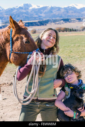 Attraktive Mutter; jungen Sohn; Pferd und Hund posieren außerhalb auf Ranch für ein Foto Stockfoto