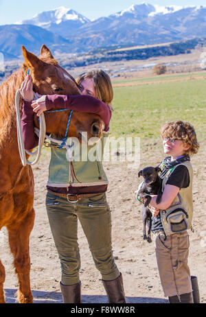 Attraktive Mutter; jungen Sohn; Pferd und Hund posieren außerhalb auf Ranch für ein Foto Stockfoto