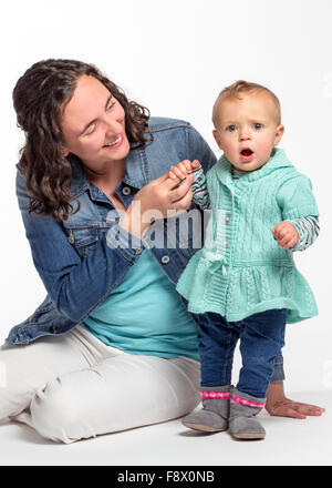 Studio Foto des jungen kaukasischen Mutter und niedliche einjährige Baby Mädchen Stockfoto