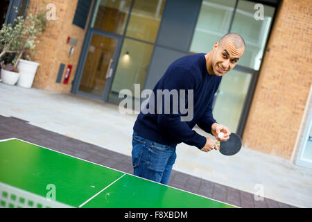 junger Mann spielen Ping-pong Stockfoto