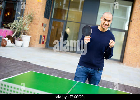 junger Mann feiert Sieg einen Punkt bei einem Spiel der Tischtennis Stockfoto