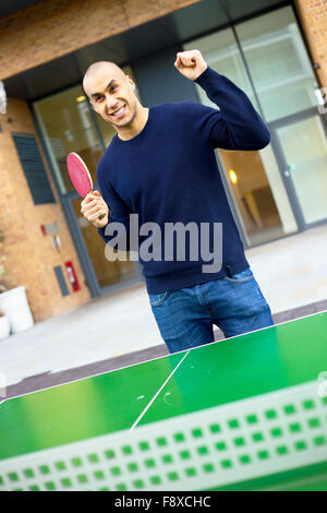 junger Mann feiert eine Ping-Pong-Spiel zu gewinnen Stockfoto