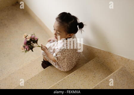 Hübsches kleines Mädchen einen Blumenstrauß Colouful in ihren Händen hält Stockfoto