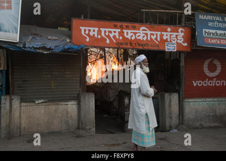 Nerul, Indien 12. Dezember 2015. Ein Mann geht vorbei an einem großen Brand, der am Фекиром Markt in der Nähe der Jama Masjid in Sektor 15, Nerul, Navi Mumbai ausbrach. Bildnachweis: Tapas Ganesh/Alamy Live-Nachrichten Stockfoto