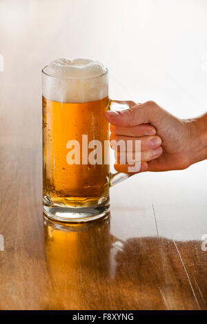 Barkeeper mit einem frisch gezapften Glas Bier in der Hand. Stockfoto