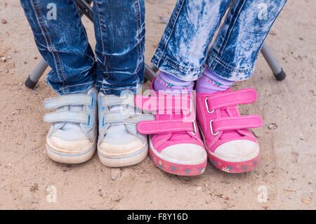 Nahaufnahme von zwei Paaren von Kinder Füße Mädchen gekleidet in Jeans und sneakers Stockfoto