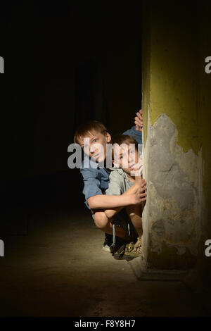 Kleine Jungs in einem dunklen Keller Stockfoto