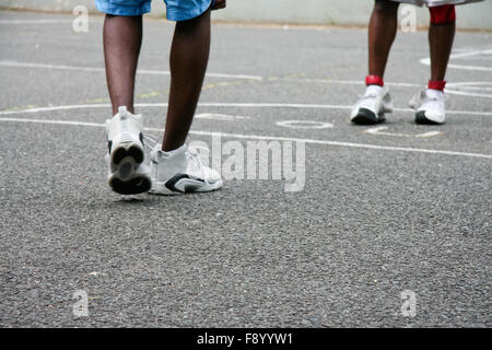 Zwei schwarze Jungs spielen in einem Harlem Basketballplatz, Ketteverbindung Zaun Boxen Stockfoto