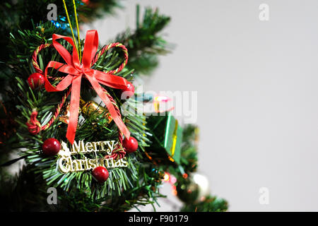 Frohe Weihnachtskranz geschmückt am Weihnachtsbaum mit Exemplar auf weißem Hintergrund Stockfoto