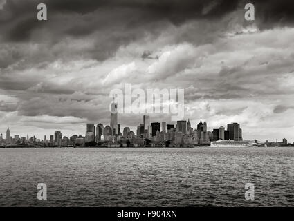 New York Harbor & schwarz-weiß Sicht auf Lower Manhattan, New York. One World Trade Center steigt in Richtung niedrige Wolken Stockfoto