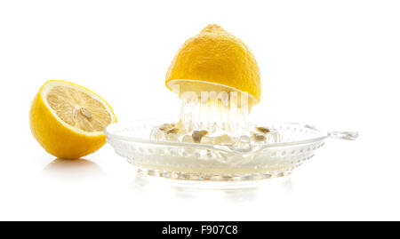 Glas Zitrus Saftpresse mit Zitronen und Saft auf weißem Hintergrund Stockfoto