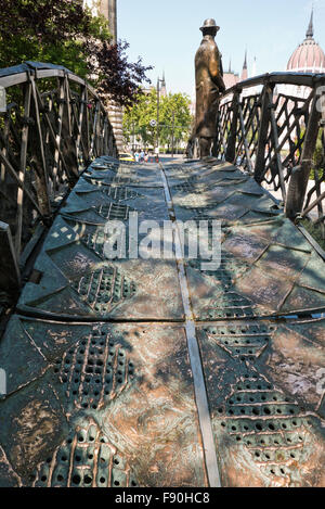 Eine Skulptur von Imre Nagy, ein Mann auf einer kleinen Brücke mit Blick auf das Parlamentsgebäude, Budapest, Ungarn. Stockfoto