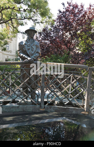 Eine Skulptur von Imre Nagy, ein Mann auf einer kleinen Brücke mit Blick auf das Parlamentsgebäude, Budapest, Ungarn. Stockfoto