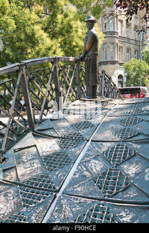 Eine Skulptur von Imre Nagy, ein Mann auf einer kleinen Brücke mit Blick auf das Parlamentsgebäude, Budapest, Ungarn. Stockfoto