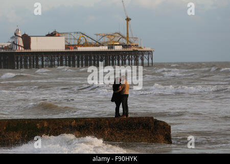 Ein paar Küsse auf einem Steg vor Brighton Pier in Brighton, UK Stockfoto