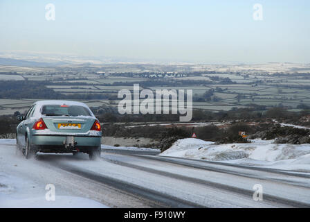 Dartmoor im Winter. Auto fahren bergab Schweinefleisch in schwierigen, eisig, Bedingungen in Richtung Tavistock, Devon, UK Stockfoto