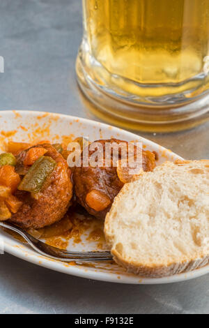 Traditionelle spanische Fleischbällchen Tapa serviert mit einem Glas Bier Stockfoto